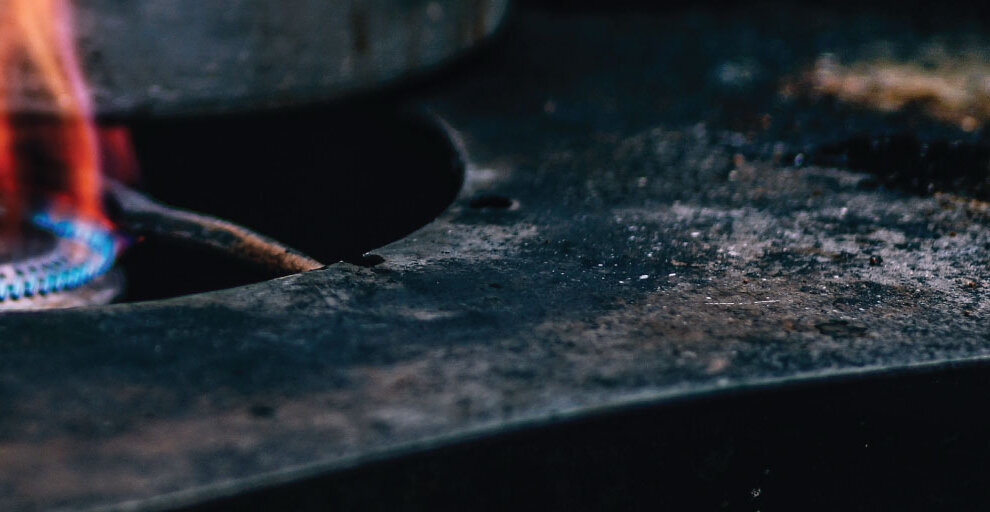 Gas flame beneath a dark stovetop surface