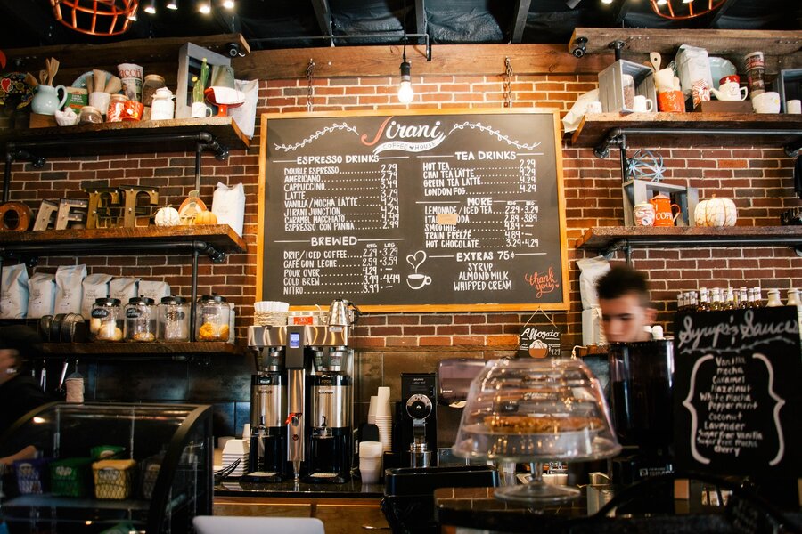Espresso machine and chalkboard menu board at a coffee counter