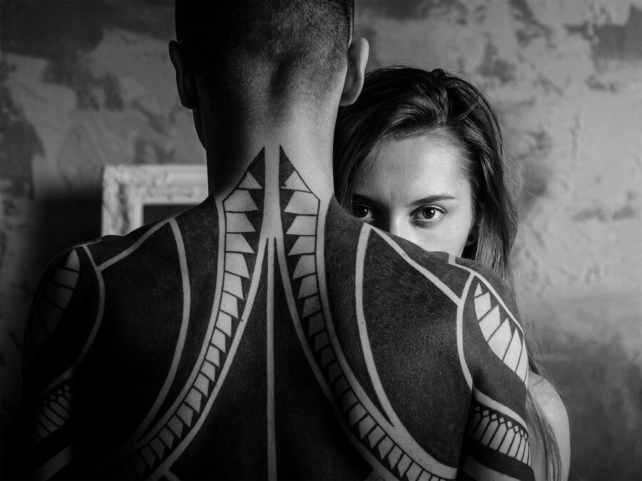 Monochrome portrait of two people standing back to back