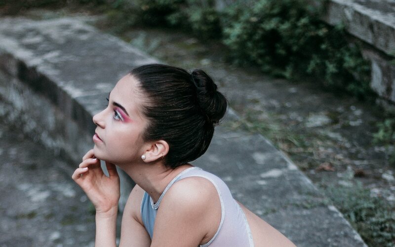 Dancer seated on stone steps in a quiet moment