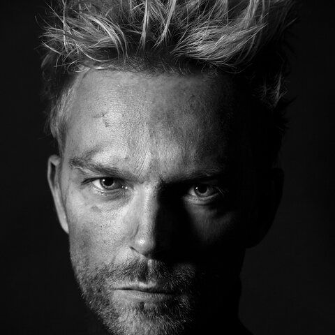 Dramatically lit black-and-white portrait, cropped square
