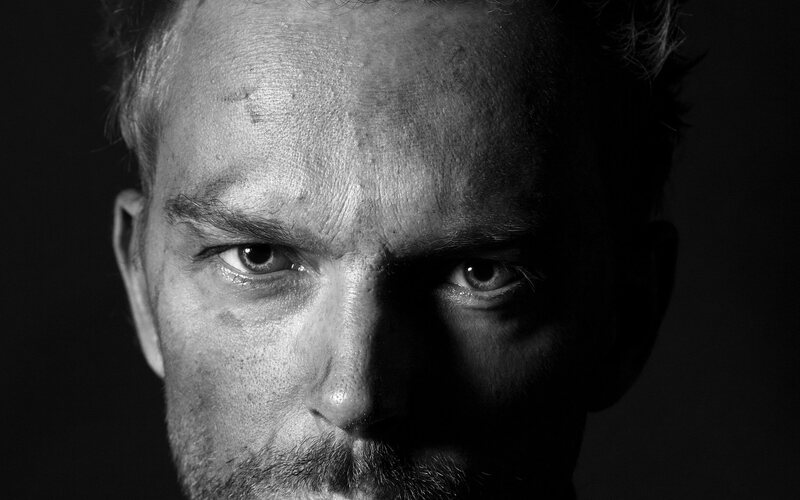 Dramatically lit black-and-white portrait