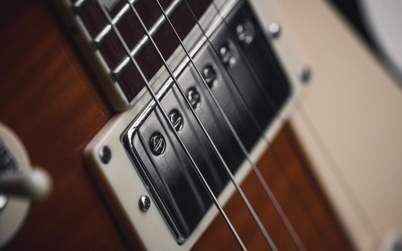 Close-up of an electric guitar's pickup and strings
