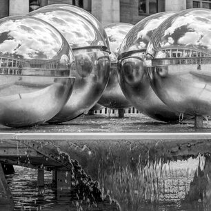 Row of large mirrored spheres in a fountain