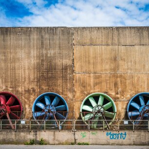 Colorful industrial cooling fans on a concrete building