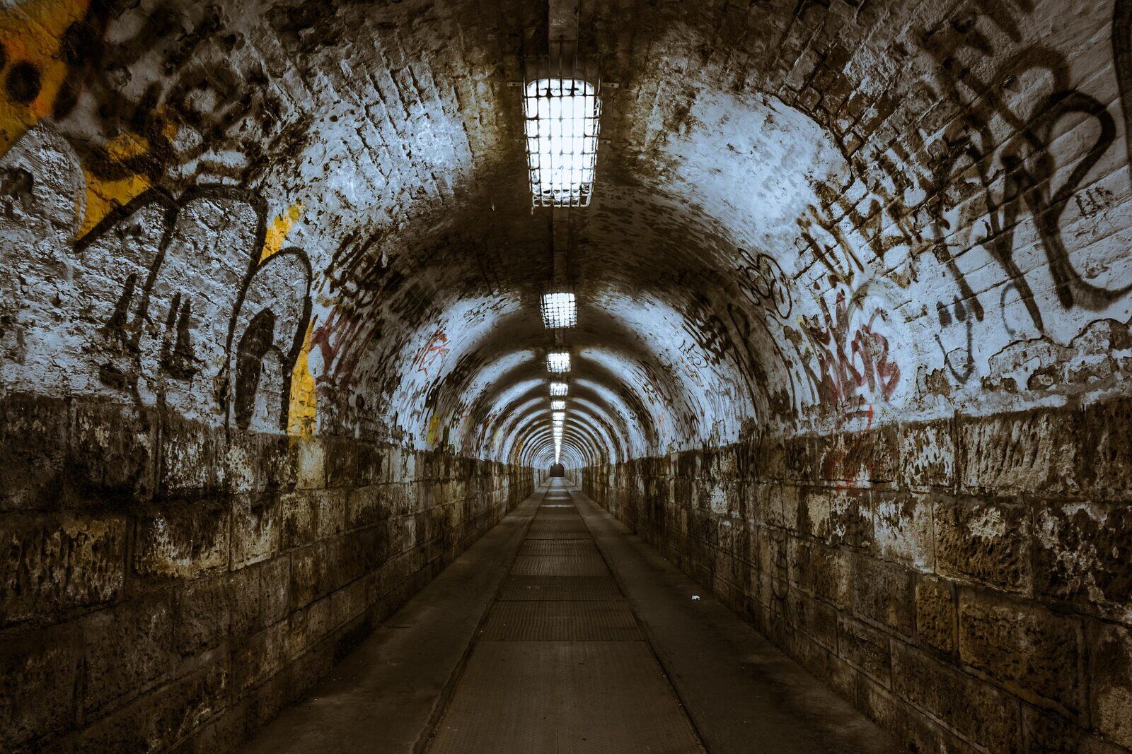 Dark graffiti-covered pedestrian tunnel
