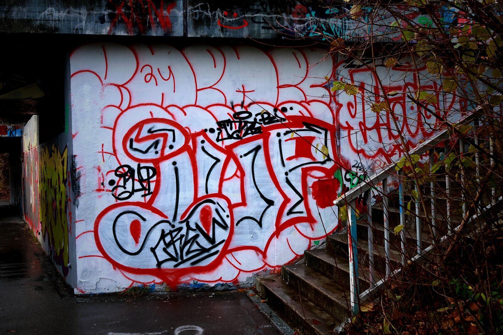 Red and white graffiti tag beside a stairwell