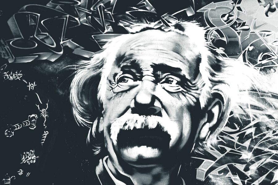 Black-and-white graffiti portrait of Albert Einstein surrounded by scrawled tags