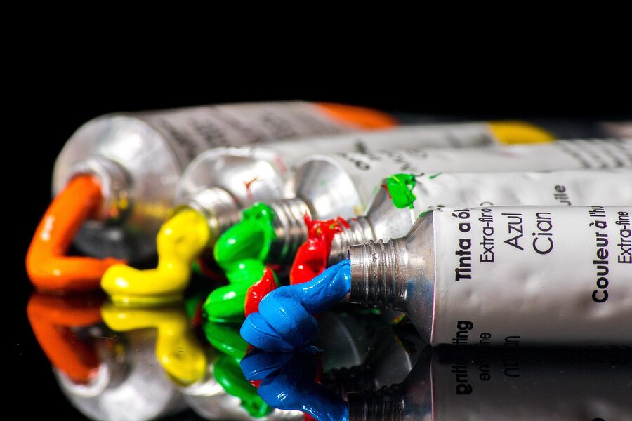 Artist's paint tubes squeezing out orange, yellow, green, red, and blue paint