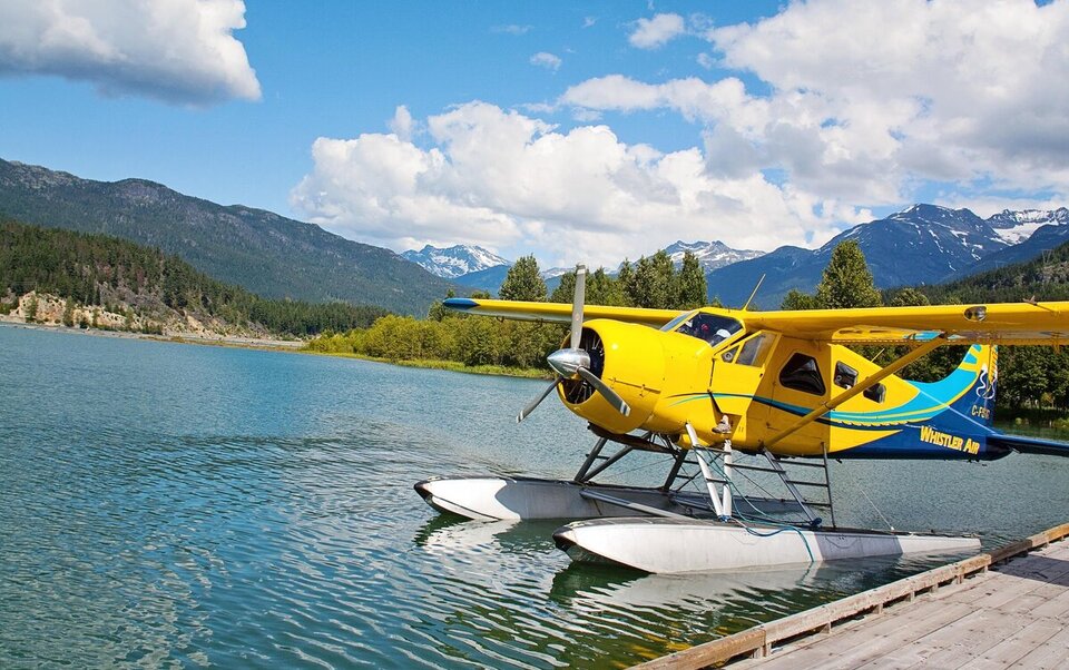 Yellow floatplane docked on a mountain lake