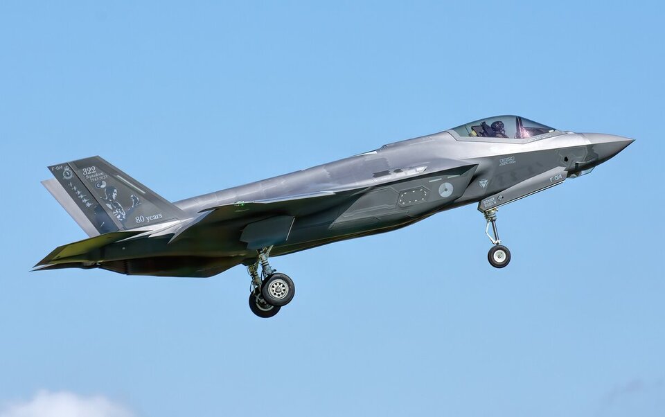 F-35 fighter jet climbing against a blue sky